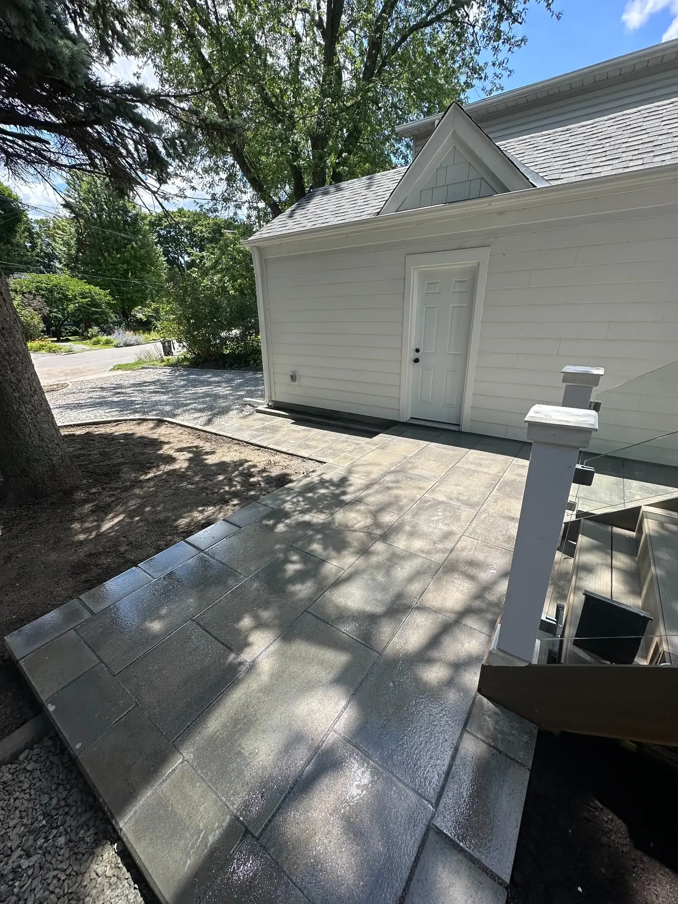 Large-format paver patio beside a renovated Toronto home.